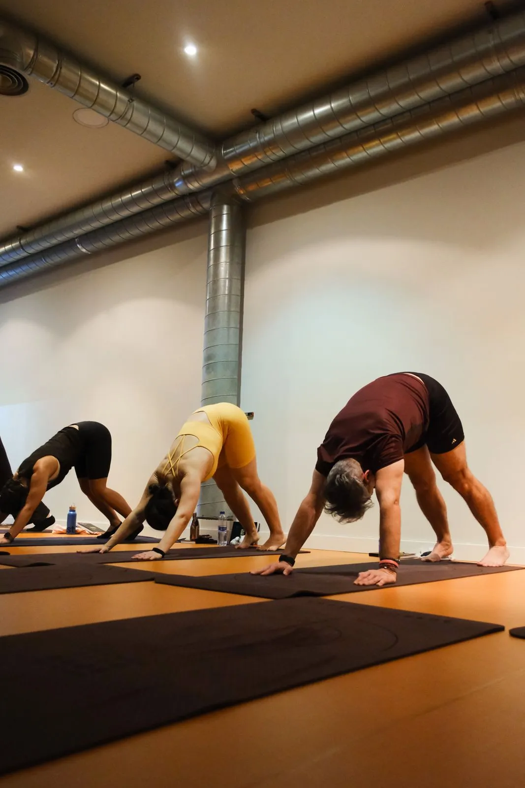 Sesión de yoga de After con varias personas en la postura del perro boca abajo