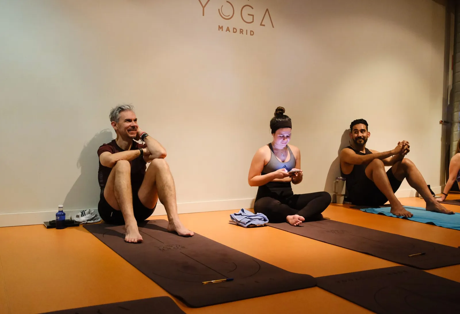 Asistentes de After sentados en las esterillas durante una charla en un estudio de yoga
